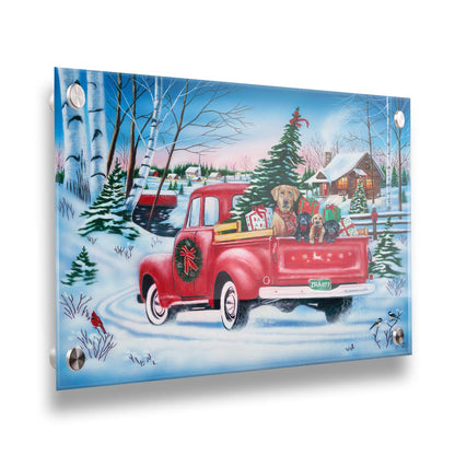 A painting of a little red pickup truck, carrying presents, a Christmas tree, and a family of puppies. It is drivng down a snowy path toward a cozy, inviting log cabin in the distance. Printed on acrylic.