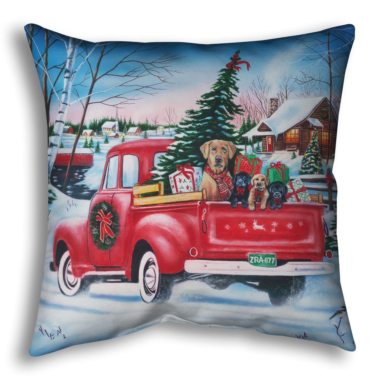Festive throw pillow with a red truck carrying a Christmas tree, puppies, and presents in a snowy village scene.