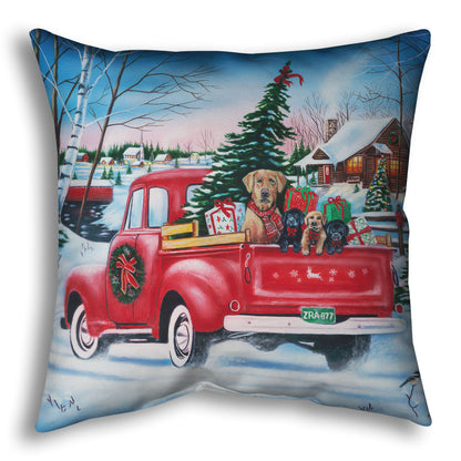 Festive throw pillow with a red truck carrying a Christmas tree, puppies, and presents in a snowy village scene.