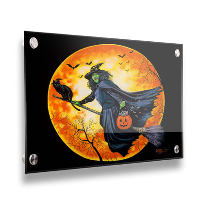 A painting of a witch, flying on a broom in front of an orange moon while carrying a pumpkin-shaped basket of candy. Printed on acrylic.