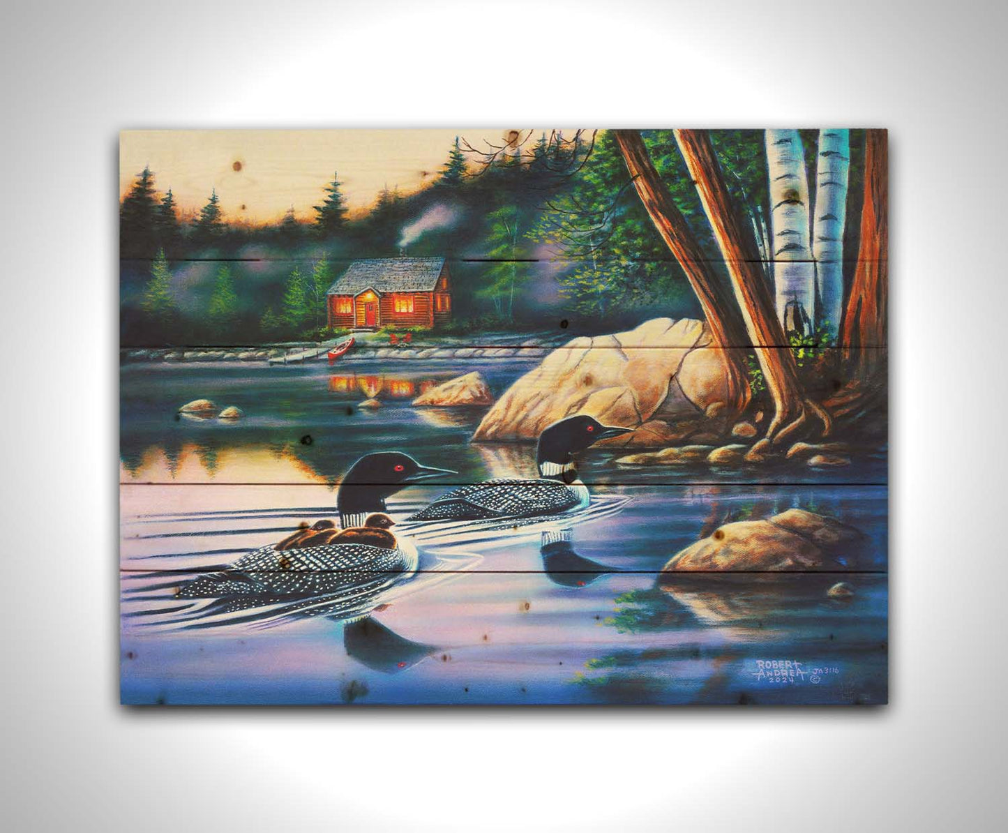 A painting of a family of loons swimming on a lake carrying their young. A pier extends to a cabin in the woods in the background. Printed on a wood pallet.