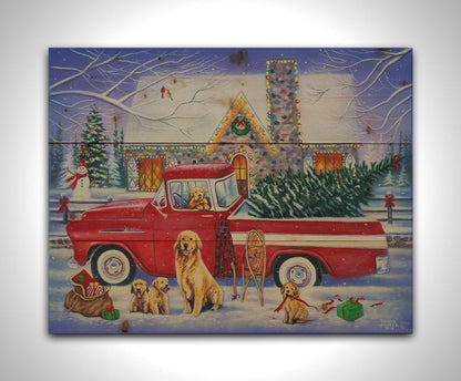 A painting of a red truck, parked in the snow outside a stone house decorated with Christmas lights. An evergreen is in the bed of the truck, and a family of golden retrievers sit in and around the vehicle. Printed on a wood pallet.