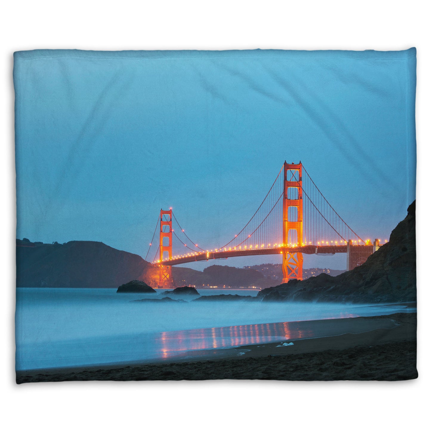 A coral fleece blanket designed with a photo from Baker Beach, San Francisco, looking out over the water at the Golden Gate Bridge.