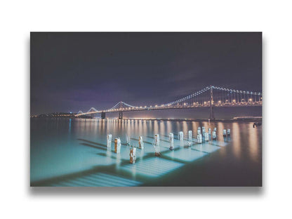 Photo of the Oakland Bay Bridge in San Francisco at night, taken from the Embarcadaro. Printed on canvas.