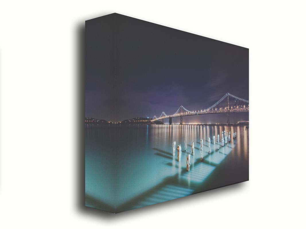 Photo of the Oakland Bay Bridge in San Francisco at night, taken from the Embarcadaro. Printed on canvas.