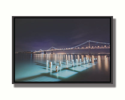 Photo of the Oakland Bay Bridge in San Francisco at night, taken from the Embarcadaro. Printed on canvas in a float frame.