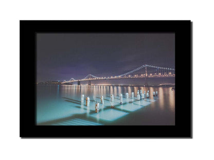 Photo of the Oakland Bay Bridge in San Francisco at night, taken from the Embarcadaro. Printed on canvas and framed.