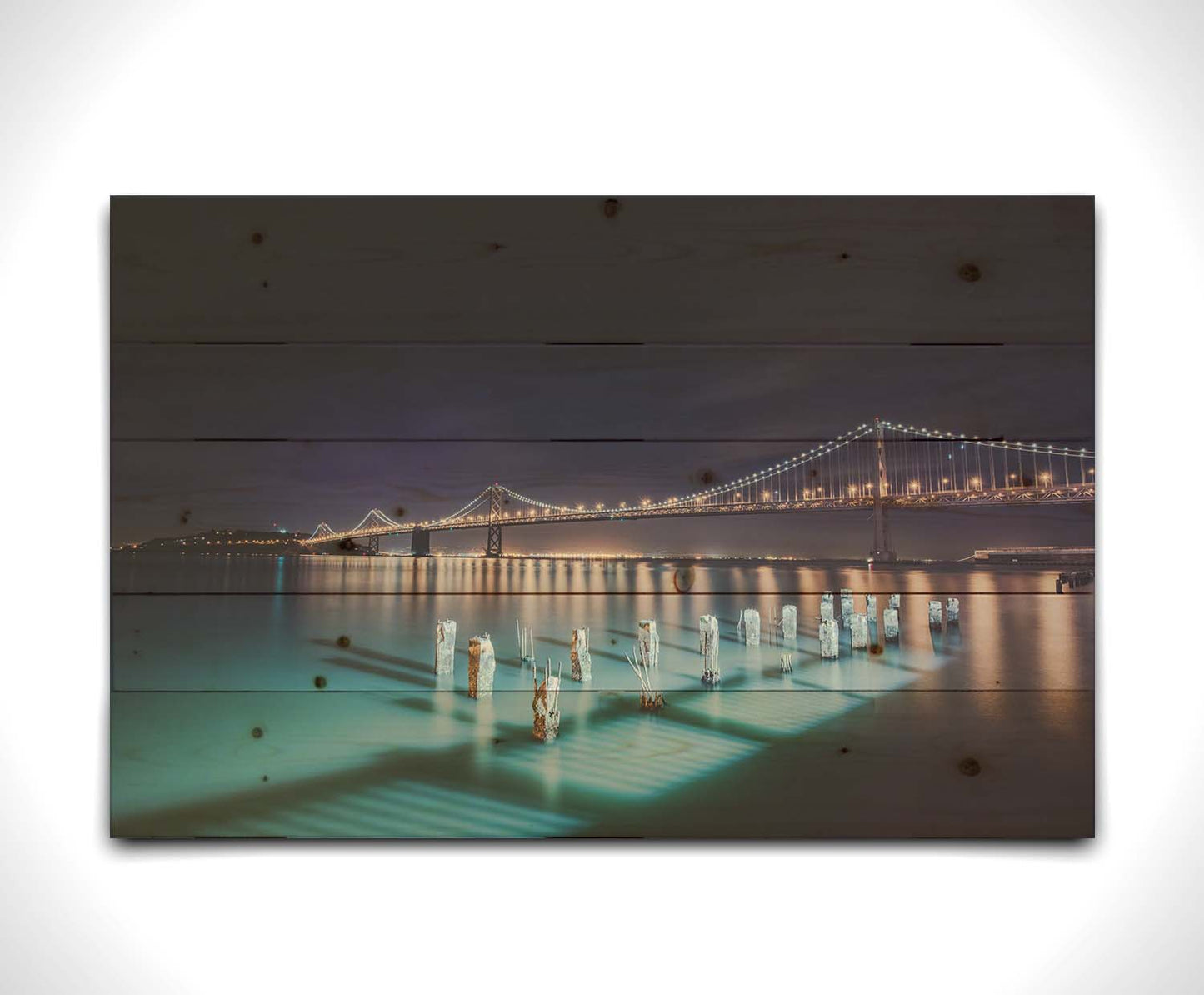 Photo of the Oakland Bay Bridge in San Francisco at night, taken from the Embarcadaro. Printed on a wood pallet.