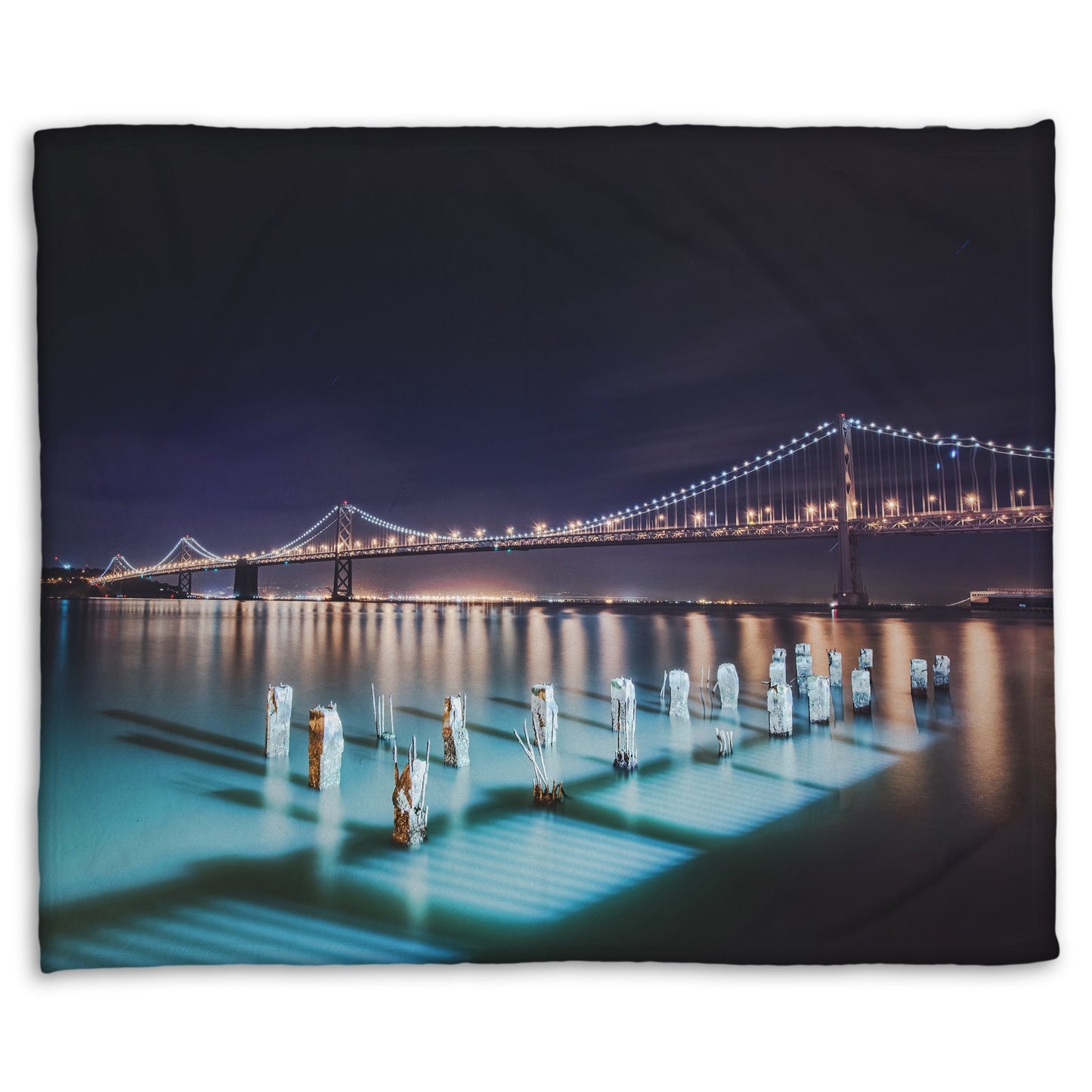 A coral fleece blanket designed with a photo of the Oakland Bay Bridge in San Francisco at night, taken from the Embarcadero.