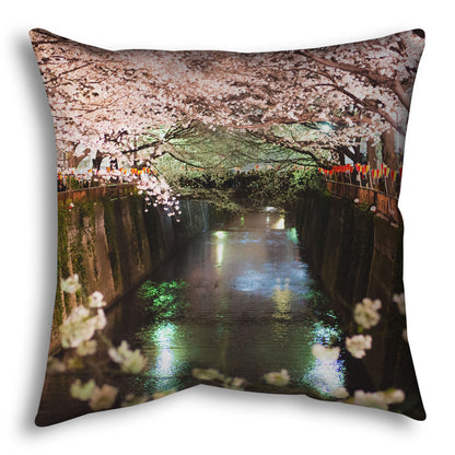 A throw pillow designed with a photo of cherry blossom trees over a canal at Meguro River in Tokyo, Japan.