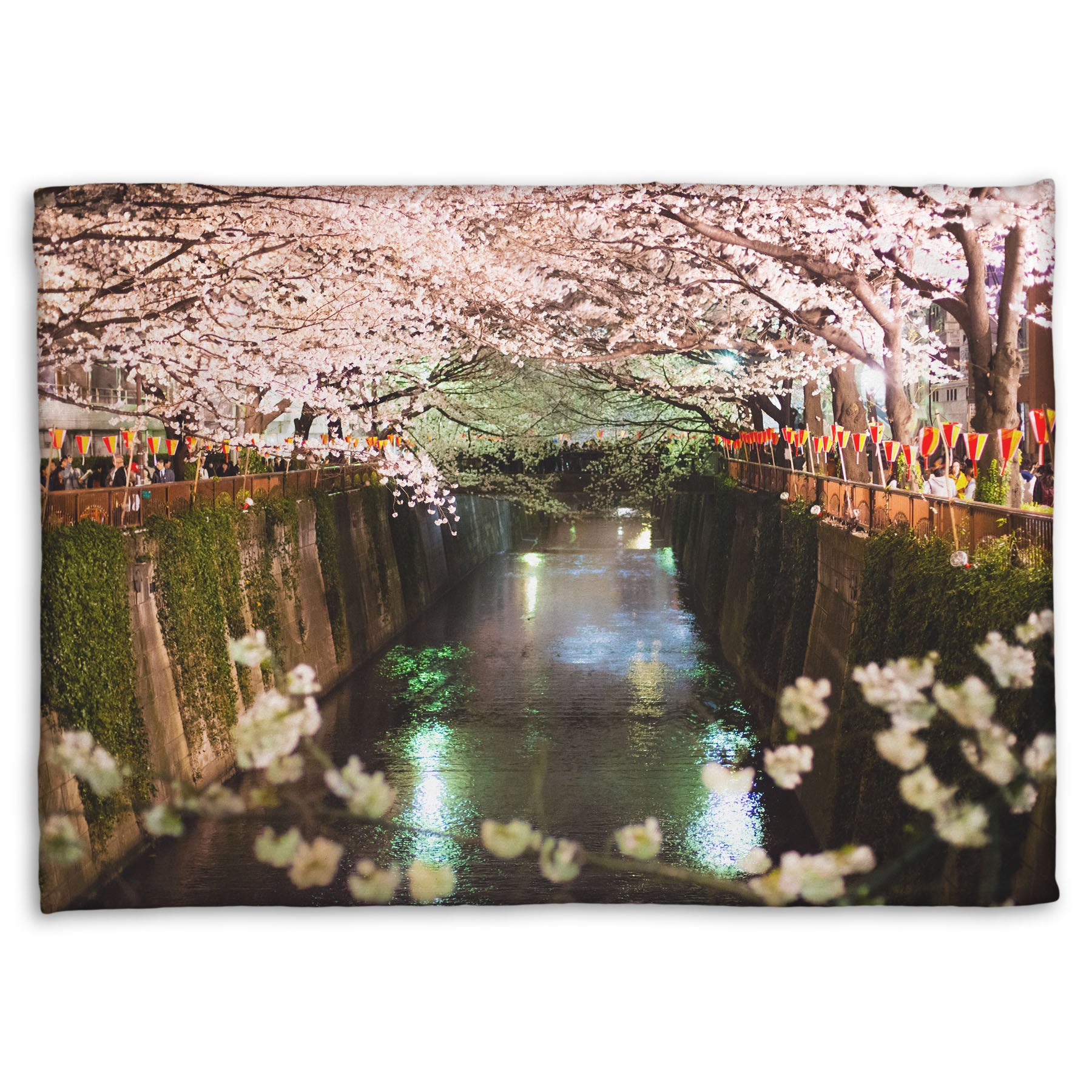 A coral fleece blanket designed with a photo of cherry blossom trees over a canal at Meguro River in Tokyo, Japan.