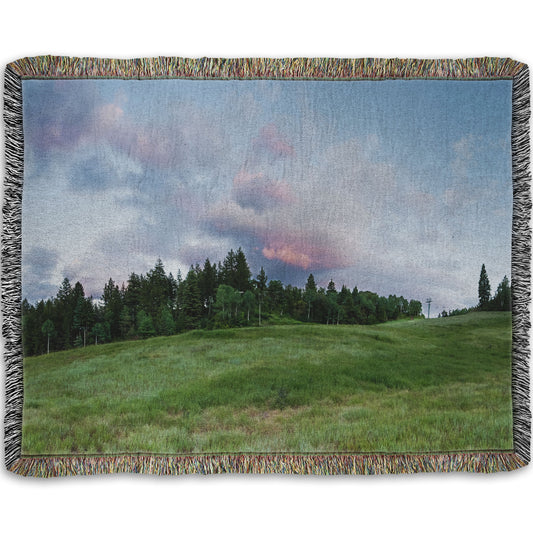 A woven throw blanket designed with a photo of the hills and sky at Sundance in Utah, at the Provo Canyon by Mount Timpanogos.