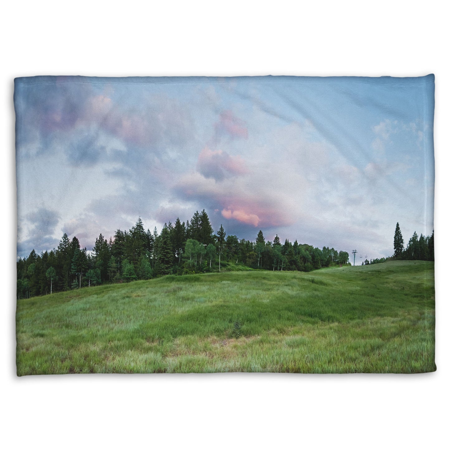 A coral fleece blanket designed with a photo of the hills and sky at Sundance in Utah, at the Provo Canyon by Mount Timpanogos.