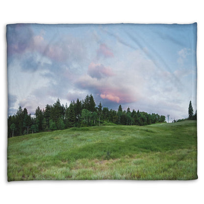 A coral fleece blanket designed with a photo of the hills and sky at Sundance in Utah, at the Provo Canyon by Mount Timpanogos.