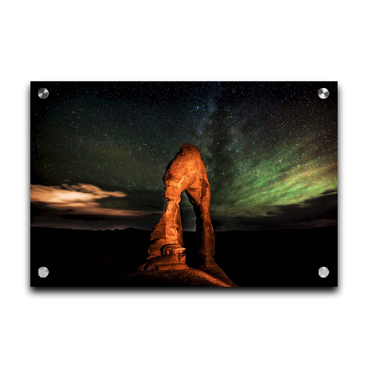 Nighttime photo of Delicate Arch in Arches National Park, Utah. The arch is lit with staged lighting, with a backdrop of a starry night sky. Printed on acrylic.