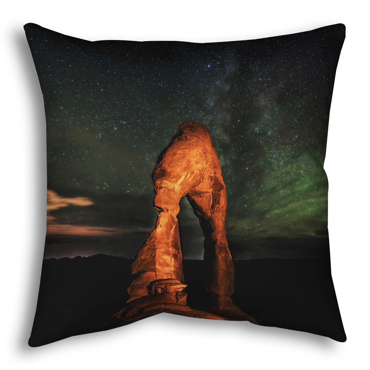 Throw pillow designed with a nighttime photo of Delicate Arch in Arches National Park, Utah. The arch is lit with staged lighting, with a backdrop of a starry night sky.