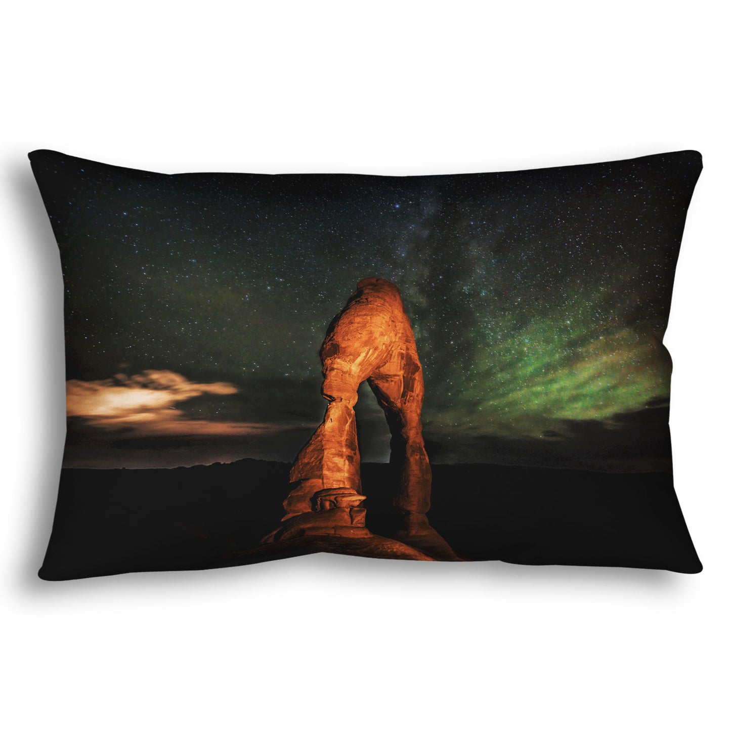 Throw pillow designed with a nighttime photo of Delicate Arch in Arches National Park, Utah. The arch is lit with staged lighting, with a backdrop of a starry night sky.