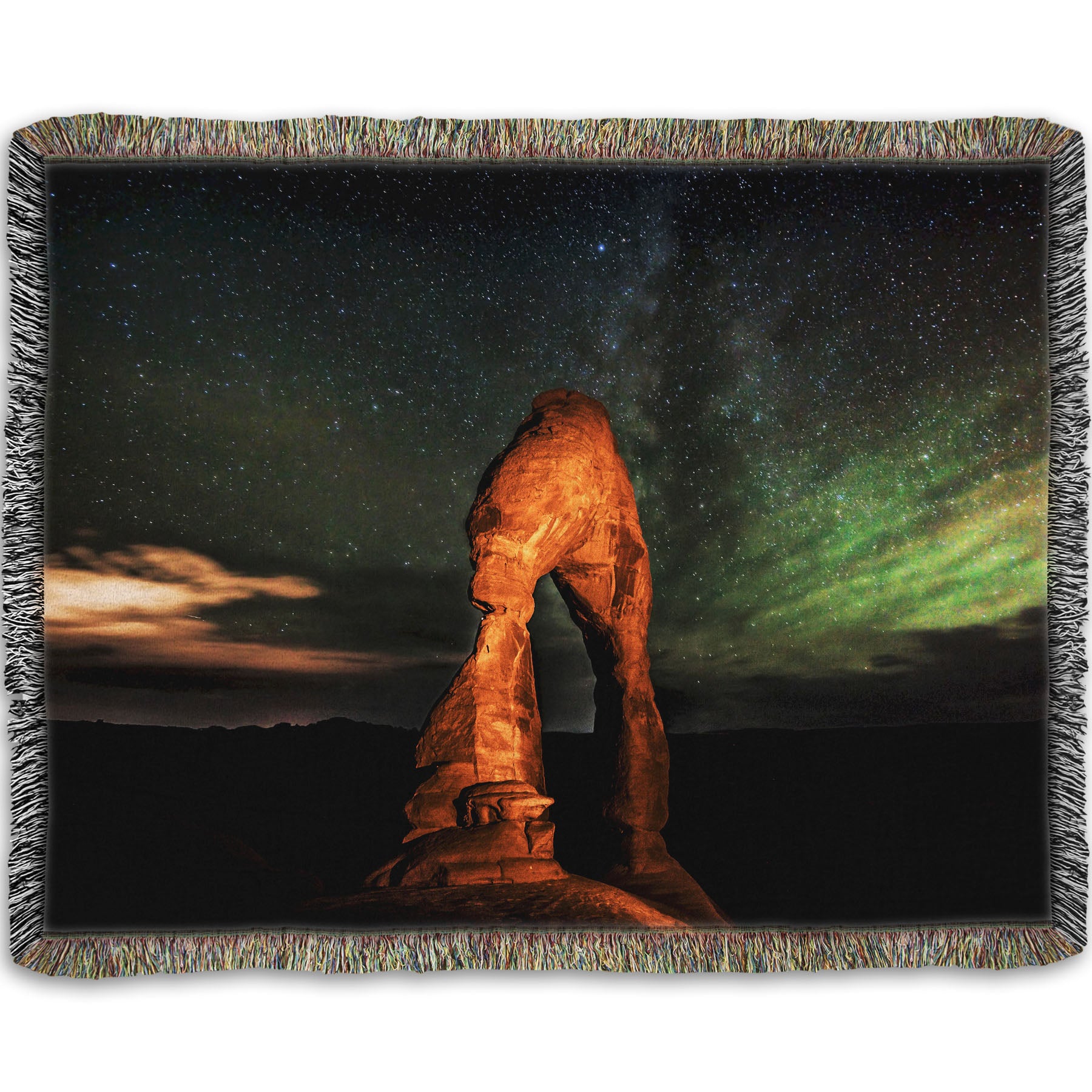 Woven throw blanket designed with a nighttime photo of Delicate Arch in Arches National Park, Utah. The arch is lit with staged lighting, with a backdrop of a starry night sky.