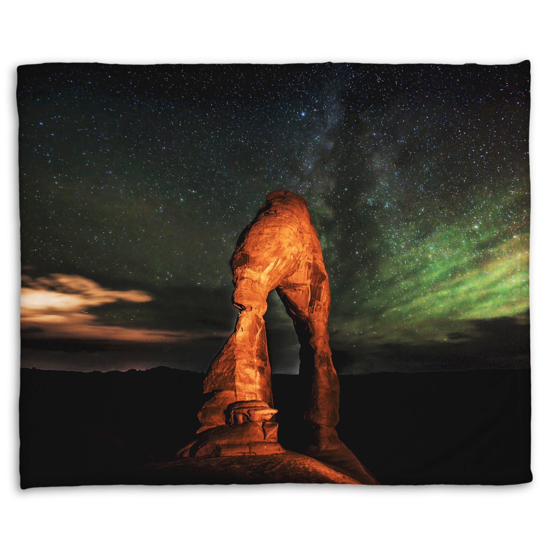 Coral fleece blanket designed with a nighttime photo of Delicate Arch in Arches National Park, Utah. The arch is lit with staged lighting, with a backdrop of a starry night sky.