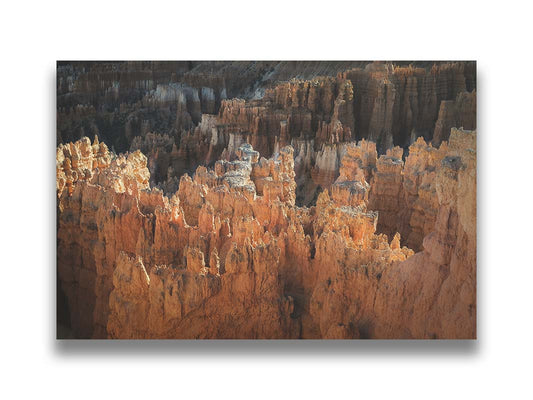 A photo of hoodoo rock formations, jagged stone spires formed by the erosion of a plateau, in Bryce Canyon National Park from a high angle. Printed on canvas.