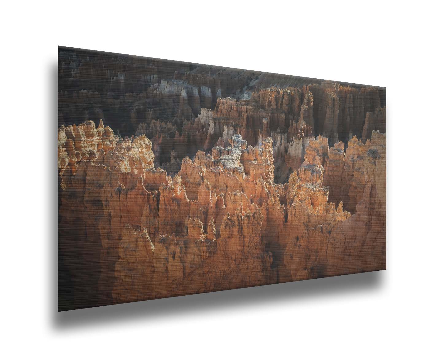 A photo of hoodoo rock formations, jagged stone spires formed by the erosion of a plateau, in Bryce Canyon National Park from a high angle. Printed on metal.