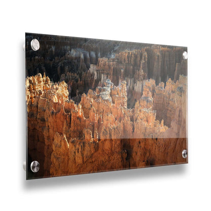 A photo of hoodoo rock formations, jagged stone spires formed by the erosion of a plateau, in Bryce Canyon National Park from a high angle. Printed on acrylic.