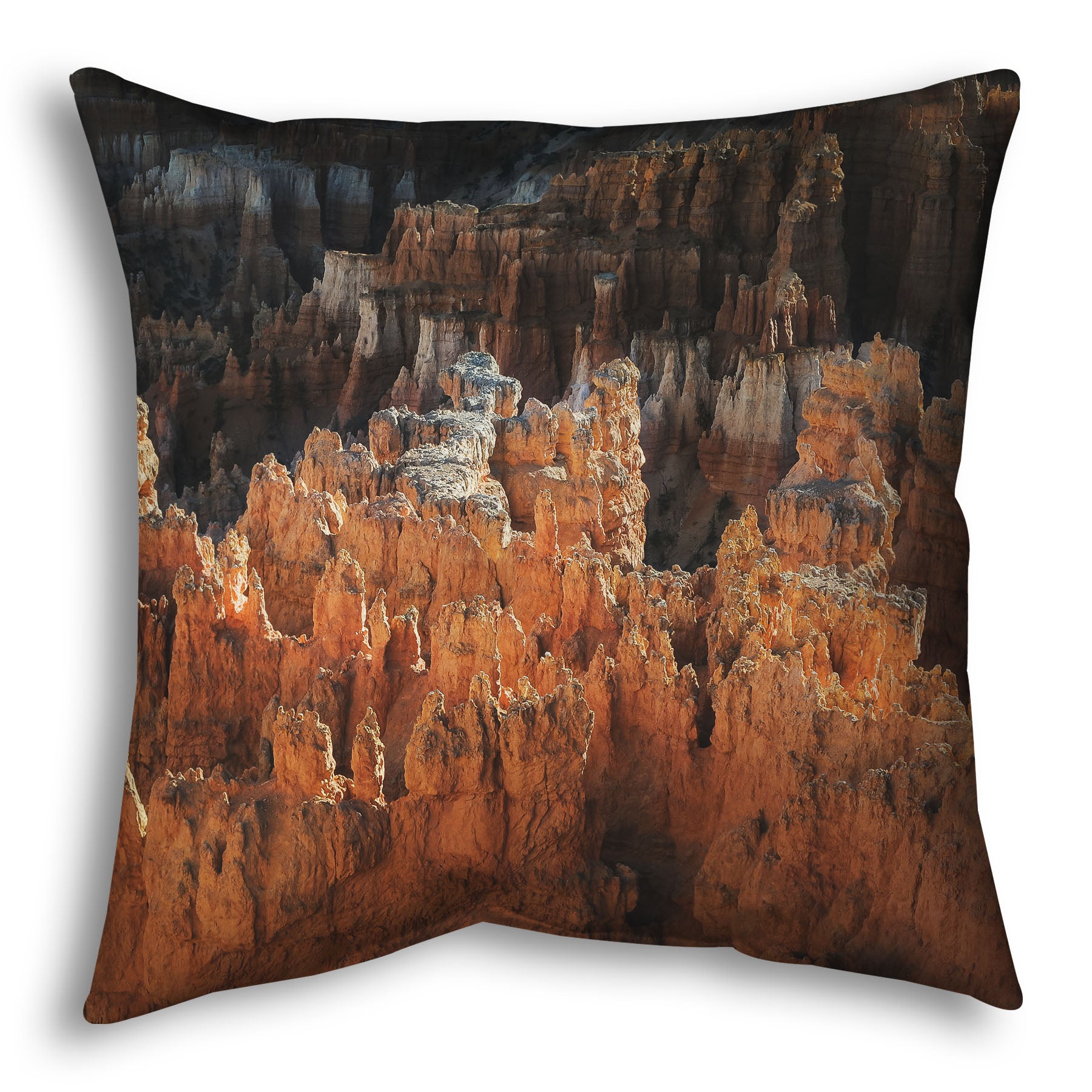 A throw pillow designed with a photo of hoodoo rock formations, jagged stone spires formed by the erosion of a plateau, in Bryce Canyon National Park from a high angle.