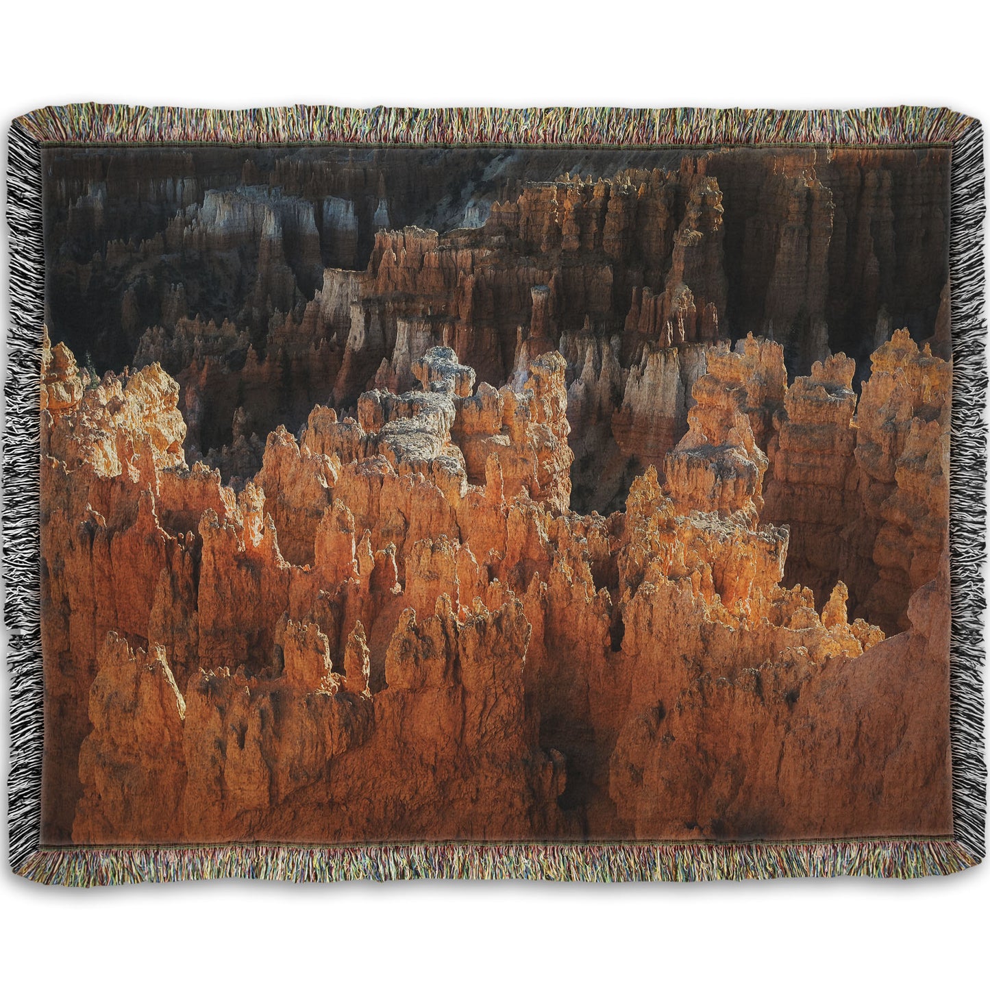 A woven blanket designed with a photo of hoodoo rock formations, jagged stone spires formed by the erosion of a plateau, in Bryce Canyon National Park from a high angle.