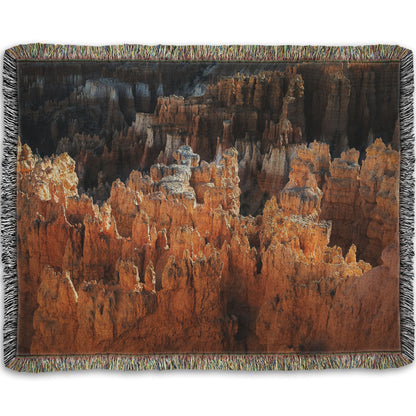 A woven blanket designed with a photo of hoodoo rock formations, jagged stone spires formed by the erosion of a plateau, in Bryce Canyon National Park from a high angle.