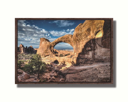 Photo of the Double O arch in the Devil's Garden at Arches National Park, Utah. The rocky arch is set against a bright blue sky. Printed on canvas in a float frame.