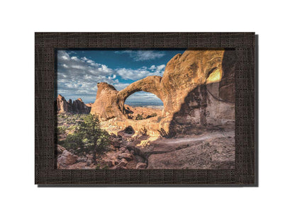 Photo of the Double O arch in the Devil's Garden at Arches National Park, Utah. The rocky arch is set against a bright blue sky. Printed on canvas and framed.