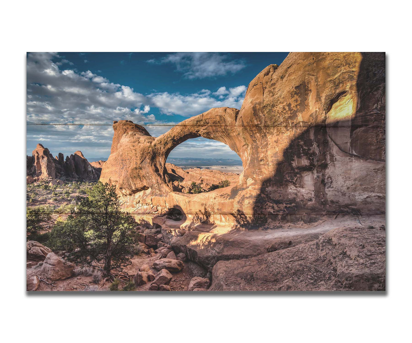 Photo of the Double O arch in the Devil's Garden at Arches National Park, Utah. The rocky arch is set against a bright blue sky. Printed on a box board.