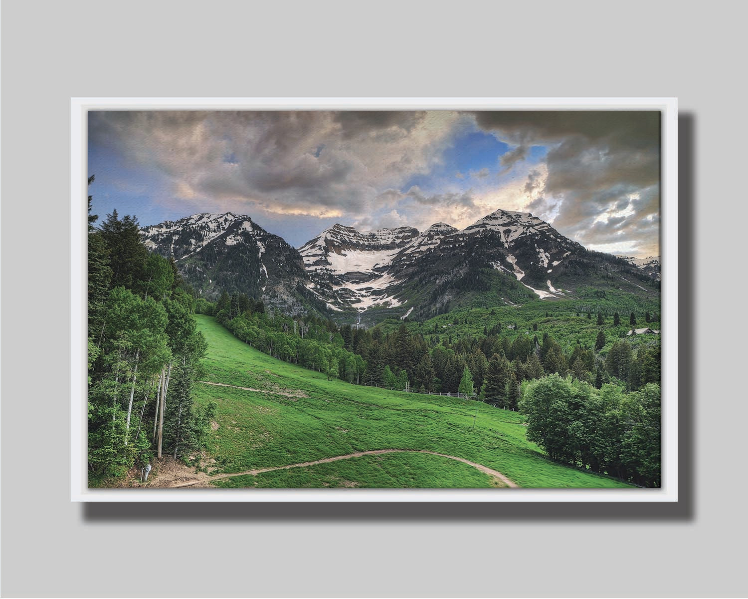 Photo of snowcapped mountains and rolling green hills and forestry, at the Sundance Ski Resort in Utah. Printed on canvas in a float frame.