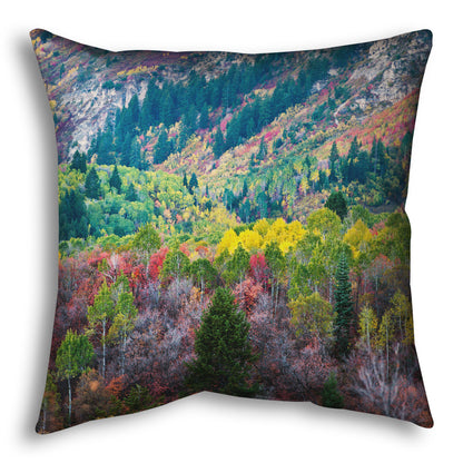 A throw pillow designed with a photo looking down on a forest at the Sundance Mountain Resort in Utah. The trees are changing colors, ranging from green, yellow, and red to no leaves at all.