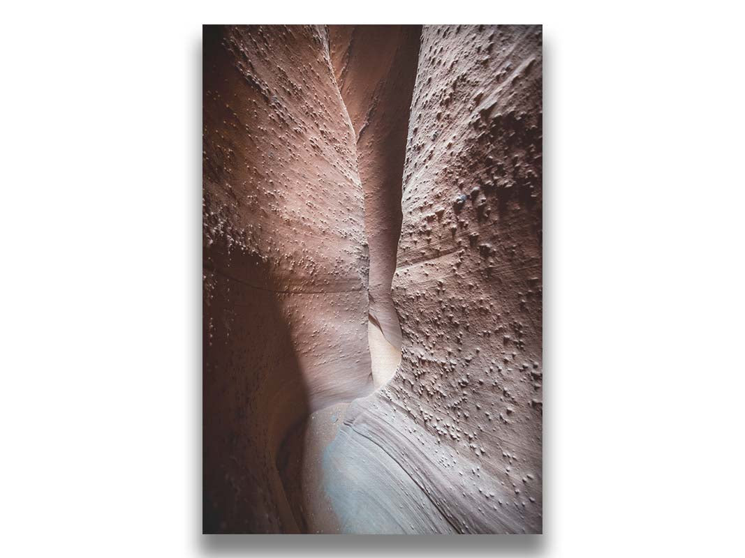 A photo of the slot canyon called Spooky near Escalante, Utah. It features a narrow crevice of lrough and smooth layers of stone. Printed on canvas.