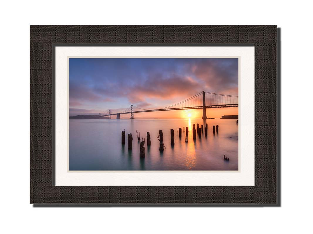 Photo of the Oakland Bay Bridge in San Francisco at sunrise, taken from the Embarcadaro. Printed on paper, matted, and framed.