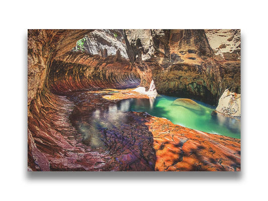 A photo from inside The Subway, or Left Fork of North Creek, at Zion National Park in Utah. It features a canyon of orange and red stone with a vibrant pool of green waters. Printed on canvas.