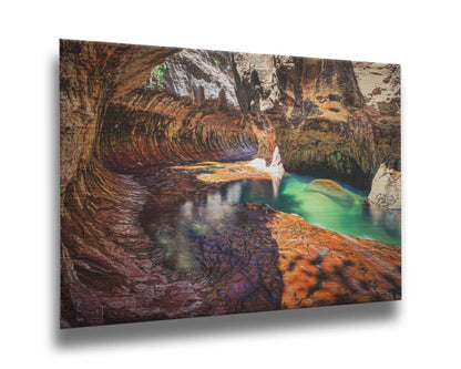 A photo from inside The Subway, or Left Fork of North Creek, at Zion National Park in Utah. It features a canyon of orange and red stone with a vibrant pool of green waters. Printed on metal.