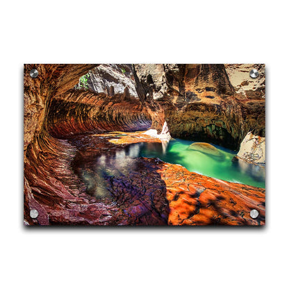 A photo from inside The Subway, or Left Fork of North Creek, at Zion National Park in Utah. It features a canyon of orange and red stone with a vibrant pool of green waters. Printed on acrylic.