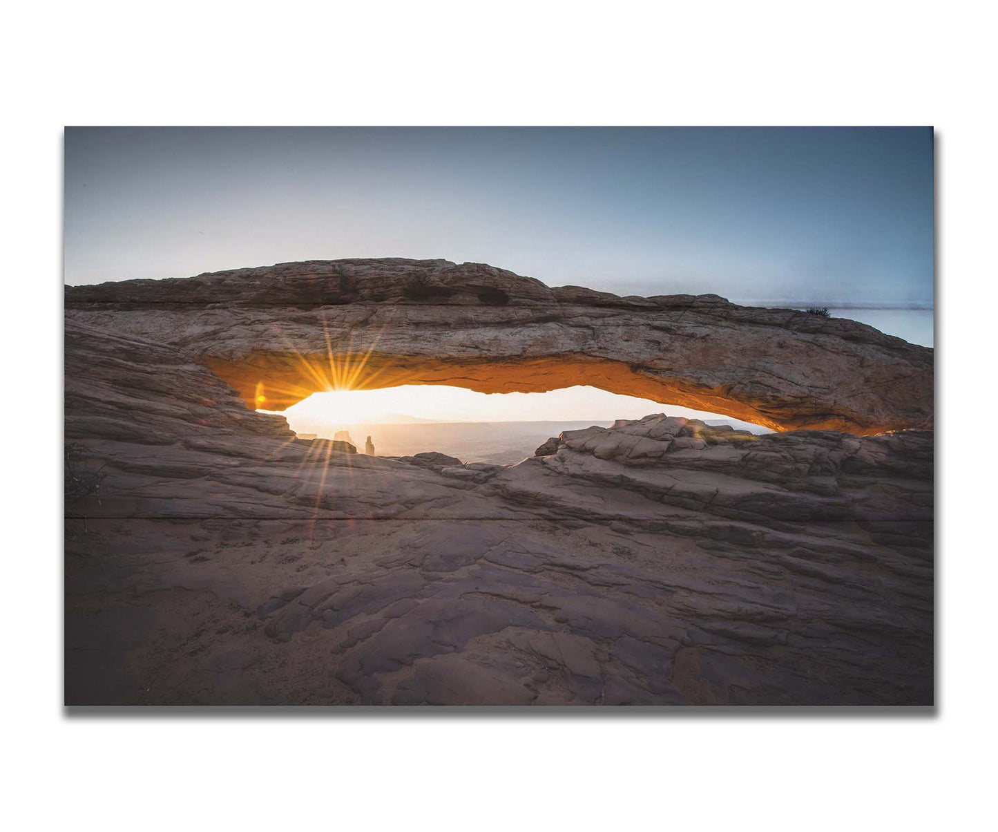 Photo of a stone arch from a national park in Utah. The sunrise site just between the horizon and the underside of the arch, creating a beautiful orange highlight to the underside of the stone structure. Printed on a box board.