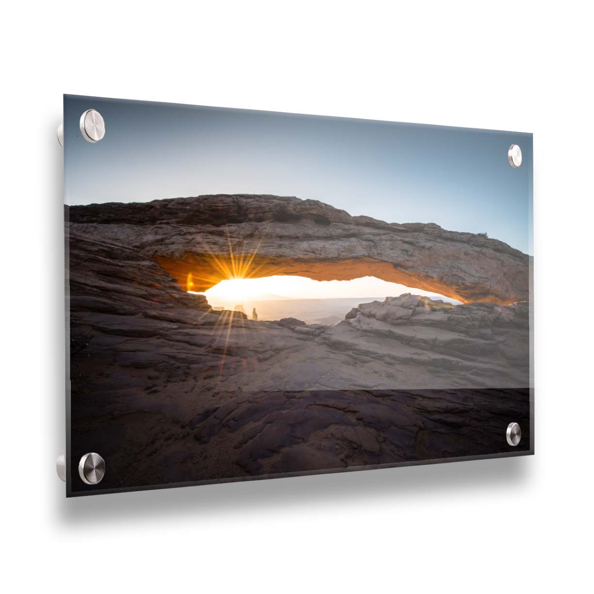 Photo of a stone arch from a national park in Utah. The sunrise site just between the horizon and the underside of the arch, creating a beautiful orange highlight to the underside of the stone structure. Printed on acrylic.