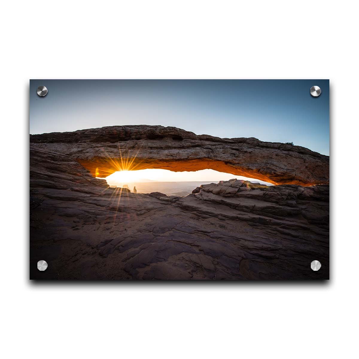 Photo of a stone arch from a national park in Utah. The sunrise site just between the horizon and the underside of the arch, creating a beautiful orange highlight to the underside of the stone structure. Printed on acrylic.