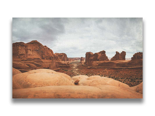 A photograph of Park Avenue at Arches National Park, looking out between rocky plateaus. Printed on canvas.