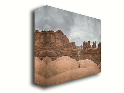 A photograph of Park Avenue at Arches National Park, looking out between rocky plateaus. Printed on canvas.