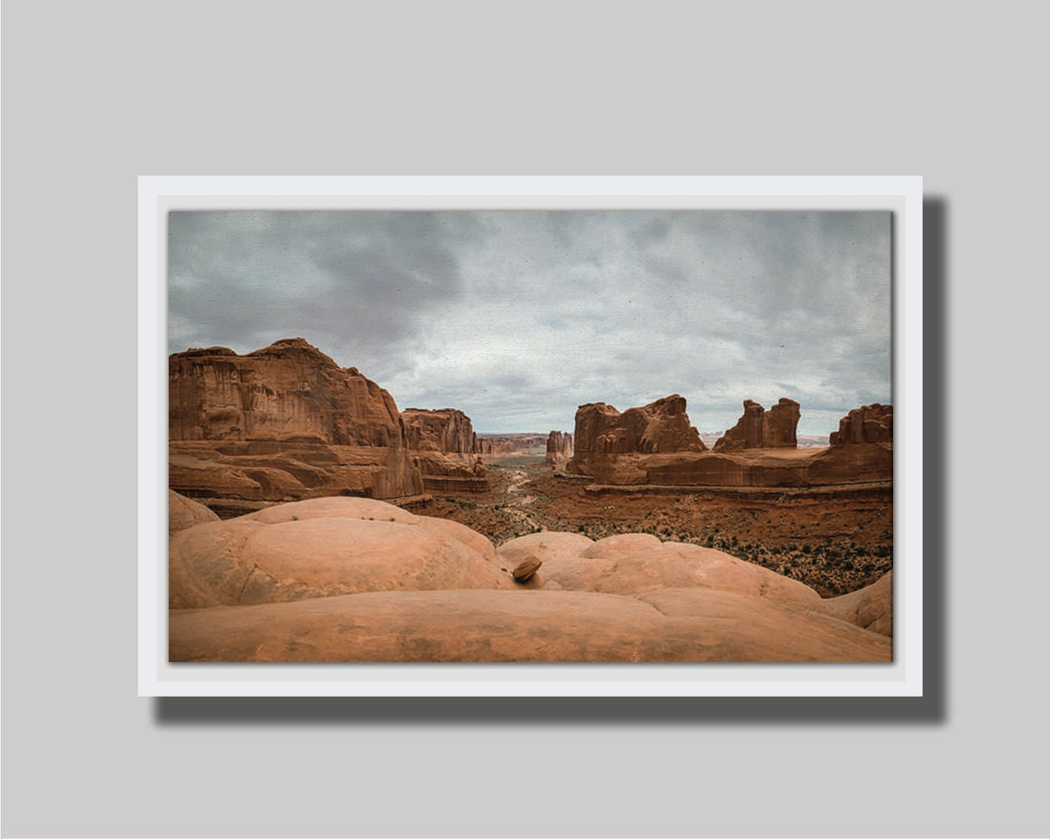 A photograph of Park Avenue at Arches National Park, looking out between rocky plateaus. Printed on canvas in a float frame.