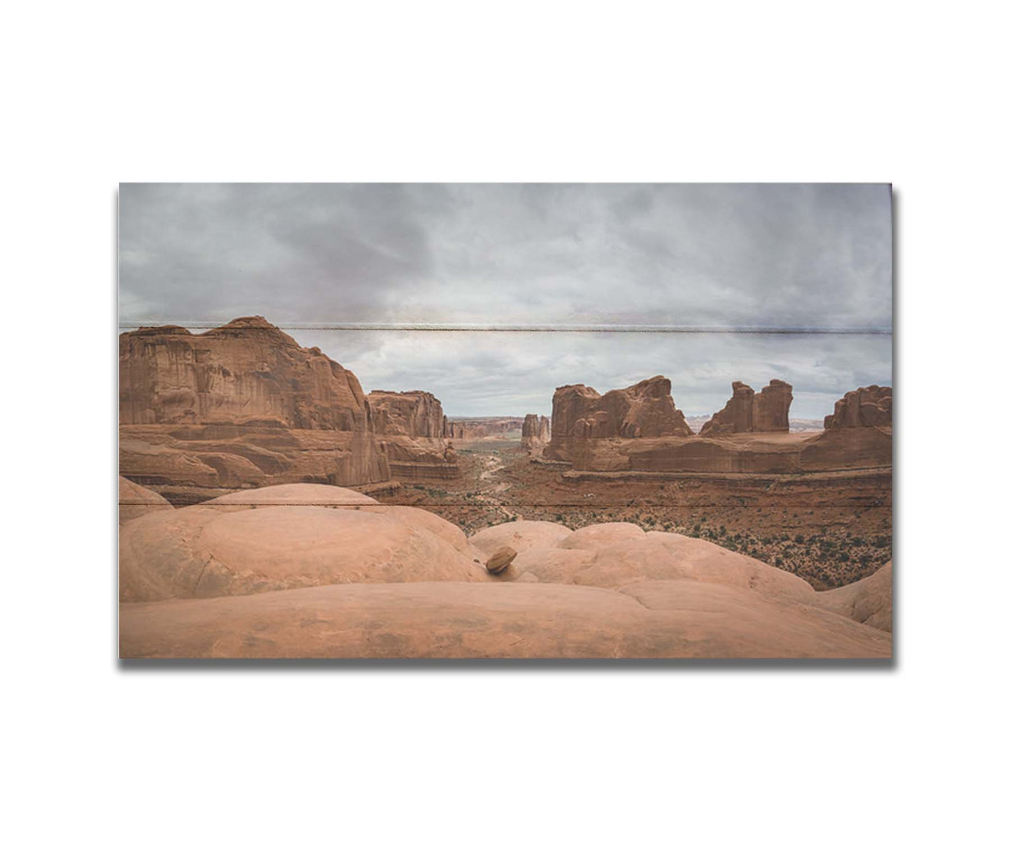 A photograph of Park Avenue at Arches National Park, looking out between rocky plateaus. Printed on a box board.