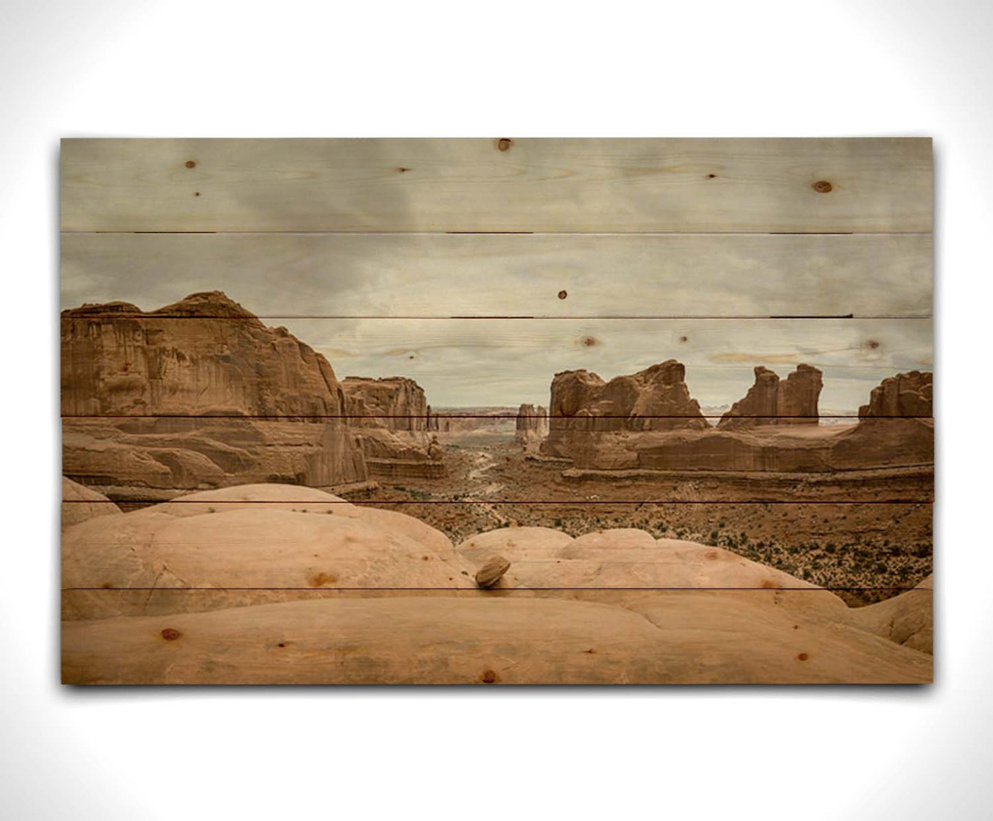 A photograph of Park Avenue at Arches National Park, looking out between rocky plateaus. Printed on a wood pallet.