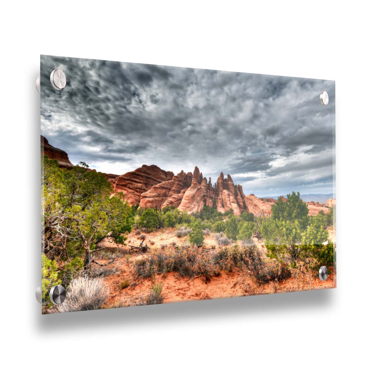 A photo of the Sandstone Fins rock formation in Arches National Park, Utah. The vertical slabs of orange sandstone stand out against the cloudy gray sky. Printed on acrylic.