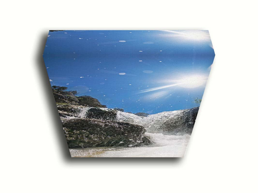 A photo looking up at the waterfalls filling the mountain hotsprings in Utah. The sky is clear and vibrant blue. Printed on canvas.