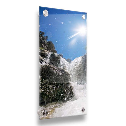 A photo looking up at the waterfalls filling the mountain hotsprings in Utah. The sky is clear and vibrant blue. Printed on acrylic.